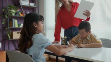 Konuşma terapisi sırasında iki farklı öğrenciye rehberlik eden İspanyol bayan öğretmen.