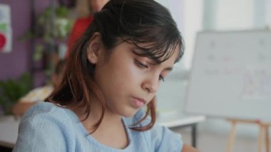 Sınıfta derste Hintli öğrencilerin yazı yazma becerilerini çekerken.