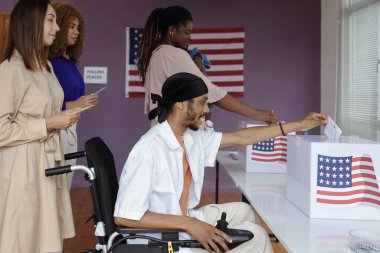 Bir grup insan oylama sırasında ilanları kutulara koyuyor.