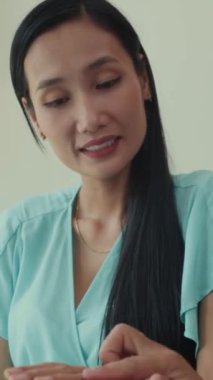 Güzellik salonundaki kadın müşteriye nasıl oje sürüleceğini açıklayan bir uzman fotoğrafı.