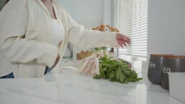 Anonim bir ev kadınının mutfak çantasından alışveriş yaparken çekilmiş görüntüsü.