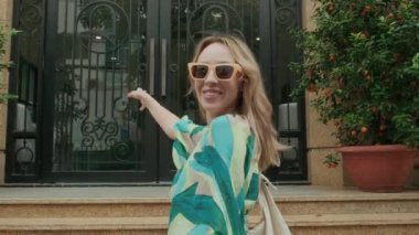 Beyaz kadın turistin yaz tatili sırasında otel lobisine giriş yaparken elde çekilmiş fotoğrafı.