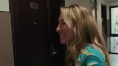 Beyaz kadın gezginin görüntüsü, tatil yaparken otel odasını kamerayla gösteriyor.