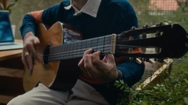 Kafkas kökenli genç müzisyenin, gitar çalarken yeni bir şarkı üzerinde çalışmasını çek.