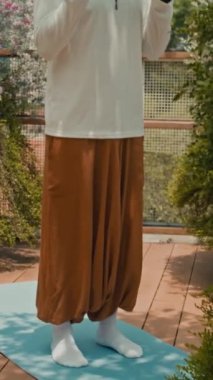 Kafkasyalı genç bir adamın dikey çekimi. Küçük dambılları kaldırıyor. Açık havada antrenman yapıyor.