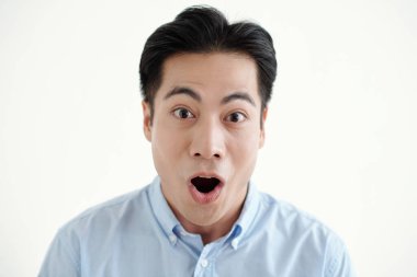 Beyaz arka planda kameraya bakan genç adam şaşırdı.