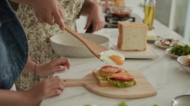 Tanınmaz haldeki büyükannesiyle torununun kahvaltıya sağlıklı bir sandviç hazırladığı sahneler.