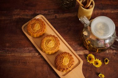 Tahta üzerinde ev yapımı keklerin ve çaydanlıkta bitki çayının üst görüntüsü.