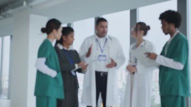 Düşük açı, üniformalı tıbbi personelin modern klinikte dururken çalışma planını tartışmalarını bulanıklaştırdı.