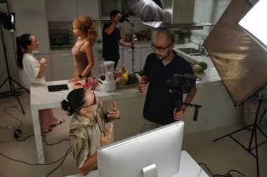 Stüdyoda işbirliği yapan operatör ve asistanlardan oluşan yüksek açılı bir görüş.