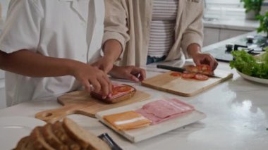 Tanımlanamayan anne ve oğlunun ev mutfağında birlikte kahvaltı yaptığı görüntüler.