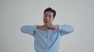 Orta boy Asyalı adamın boynu, kolları, elleri ve omuzlarıyla ısınma hareketleri.