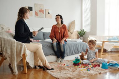 Sosyal hizmetler görevlisi, bekar anneyi evine giderken destekliyor.