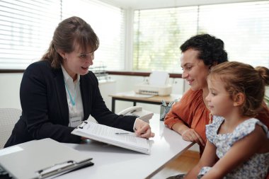 Social worker discussing agreement with family during their visit to social service clipart