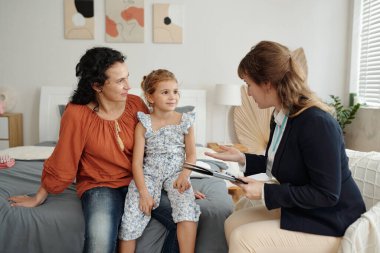 Sosyal hizmetler görevlisi evlat edinen aileyle konuşuyor.