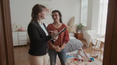 Kafkasyalı bir kadının sosyal hizmet görevlisine ev ziyareti sırasında kızlarının ihtiyaçlarını anlattığı orta boy bir fotoğraf.