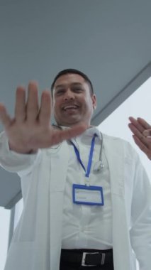 Modern hastanede başarıyı kutlayan çeşitli doktorlardan oluşan dikey çekim