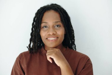 Genç bir Afrikalı Amerikalı kadın portresi Rastalı gülümseme ile elinde dinlenme çene, doğal güven ve sakinlik göstermektedir