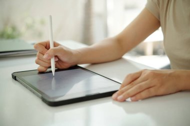 Dijital tabletle meşgul olan kişi, kapalı alanda yaratıcı proje için stil kullanıyor. Teknoloji ve modern yaratıcı süreçle el etkileşimine odaklanın