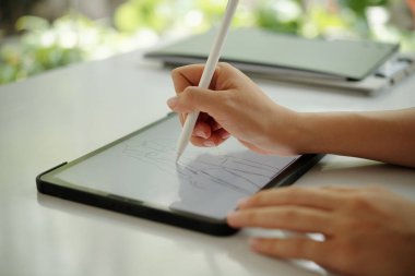 Stylus ile ustalıkla tablete çizim yaparak, modern teknolojiye odaklanarak, iyi ışıklandırılmış ortamlarda yaratıcı dijital sanat süreçlerini göstererek,