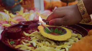 Diwali kutlamaları sırasında kimliği belirsiz bir kadının tepsiyi aydınlatırken yakın çekimi.