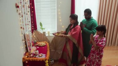 Geleneksel Diwali puja yapmak için uzun bir aile buluşması. Süslü sunağın önünde dua etmek. Işıklar, çiçekler ve tatlılar.
