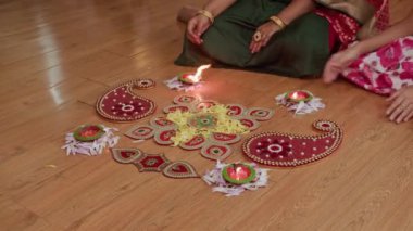 Diwali kutlamaları sırasında Rangoli tarafından yerde oturan tanınmayan aile fotoğrafı.