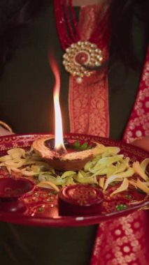 Diwali 'yi kutlarken elinde yanan bir bıçakla tanınmayan bir kadının dikey çekimi.