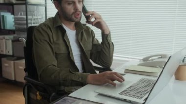 Modern ofis alanındaki dizüstü bilgisayarın önünde otururken erkek finans müdürünün cep telefonuyla konuşmasını yukarı kaldır.