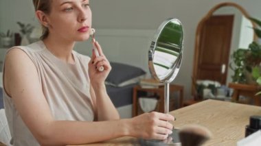 Kafkasyalı Z genli kızın rahat yatak odasında masasında otururken patenli bu aynayla yüz masajı yaparken görüntüsü.