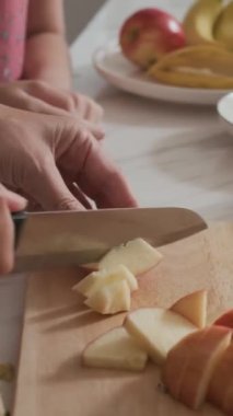 Anne ve kızının ev mutfağında meyve kahvaltısı hazırlarken dikey çekimleri.