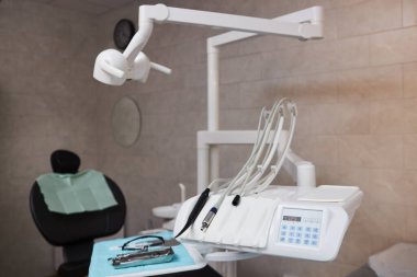 Modern diş muayenehanesinde dişçi koltuğu gelişmiş diş aletleri ve aletlerle donatılmıştır. Temiz ve düzenli bir düzen bir sonraki hasta için hazır, hijyenik ve profesyonel çevrenin sağlanması