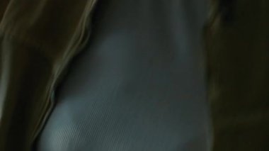 Uzun siyah kıvırcık saçlı enerjik melez kızın gece partisinde yanıp sönen ışıklar altında dans edişinin görüntüsü.