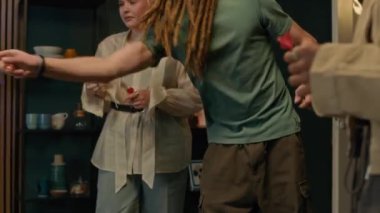 Konforlu ev ortamında dart oynarken eğlenen dört genç arkadaştan oluşan bir grup hedef tahtaya birer birer dart atıyorlar.