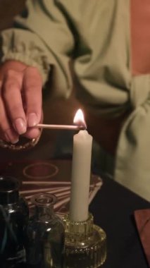 Geceleri evde fal baktırırken tanınmayan bir kadının ellerinin dikey görüntüsü.