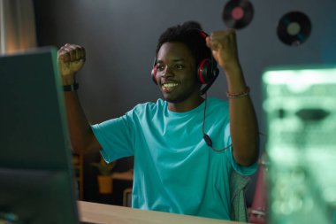 African American gamer winning the game on computer while playing online at home clipart