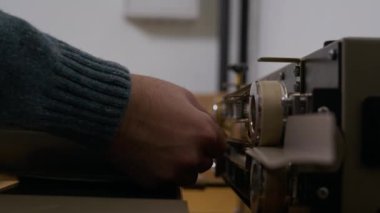 Tanımlanamayan bir uzmanın el kesimi kahve poşetini fabrikada ekipmanla süpürüyor.