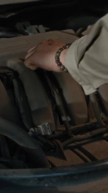 Araba atölyesinde, tanınmayan mekanikerin bujileri değiştirdiği dikey çekim