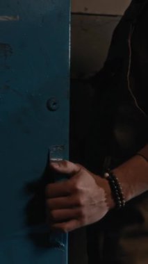 Garajda deterjanla araba yıkayan genç bir uzmanın dikey çekimi.