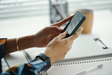 Tanımlanamayan kadın ofis çalışanlarının yakın çekimleri akıllı telefon web sayfasını kaydırıyor