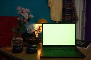 No people shot of opened laptop on cluttered wooden coffee table in girls dorm room, copy space clipart