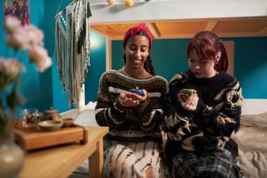 Yurttaki odalarında oturmuş çay içen iki kadının orta boy fotoğrafı.