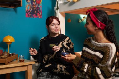 İki melez en iyi arkadaş yurt odasında birlikte vakit geçirir, konuşur ve çay içerler.