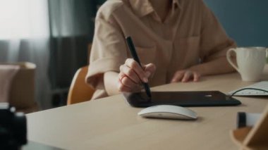 Ofiste çalışırken dijital tablet üzerinde tanımlanamayan grafik tasarımcısının el resimleri.