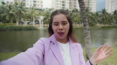 Şehir parkında video blogları yaparken günlük kıyafetleriyle konuşan çok ırklı Z kızının orta karar POV 'u.