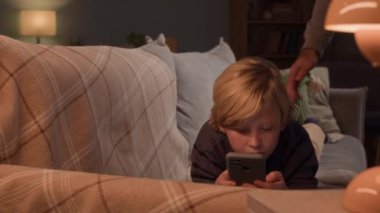 Beyaz bir babanın, hafta sonu evde oyun saatlerini kısıtlarken oğullarını akıllı telefondan almasının el kamerası görüntüsü.