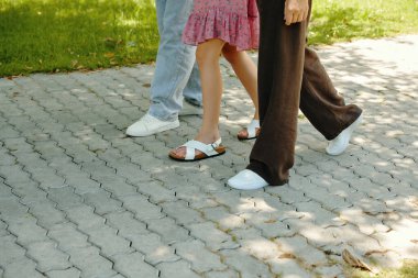 Güneşli bir günde sokakta birlikte yürüyen aile yakınları.