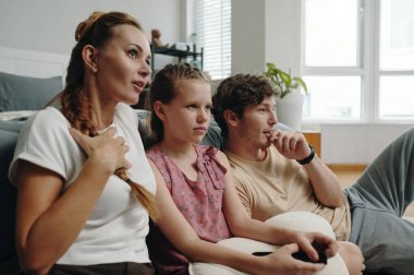 Üç kişilik aile yatak odasında oturup birlikte ilginç bir film izliyorlar.