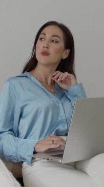 Minimalist ofis alanında kablosuz dizüstü bilgisayar üzerinde çalışırken kadın girişimcinin içme suyu dikey görüntüsü