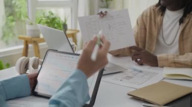 İçerde otururken iki iş arkadaşının dijital tablet ve dizüstü bilgisayarla uygulama modellemelerini tartışırkenki görüntülerini kaldır